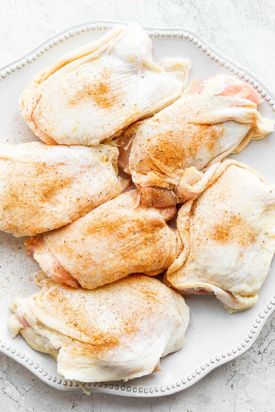 Chicken thighs with chicken seasoning on top.