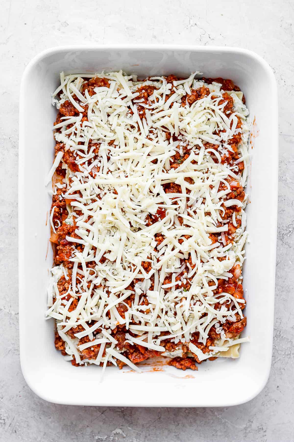 Shredded mozzarella cheese added to the top of the meat sauce.