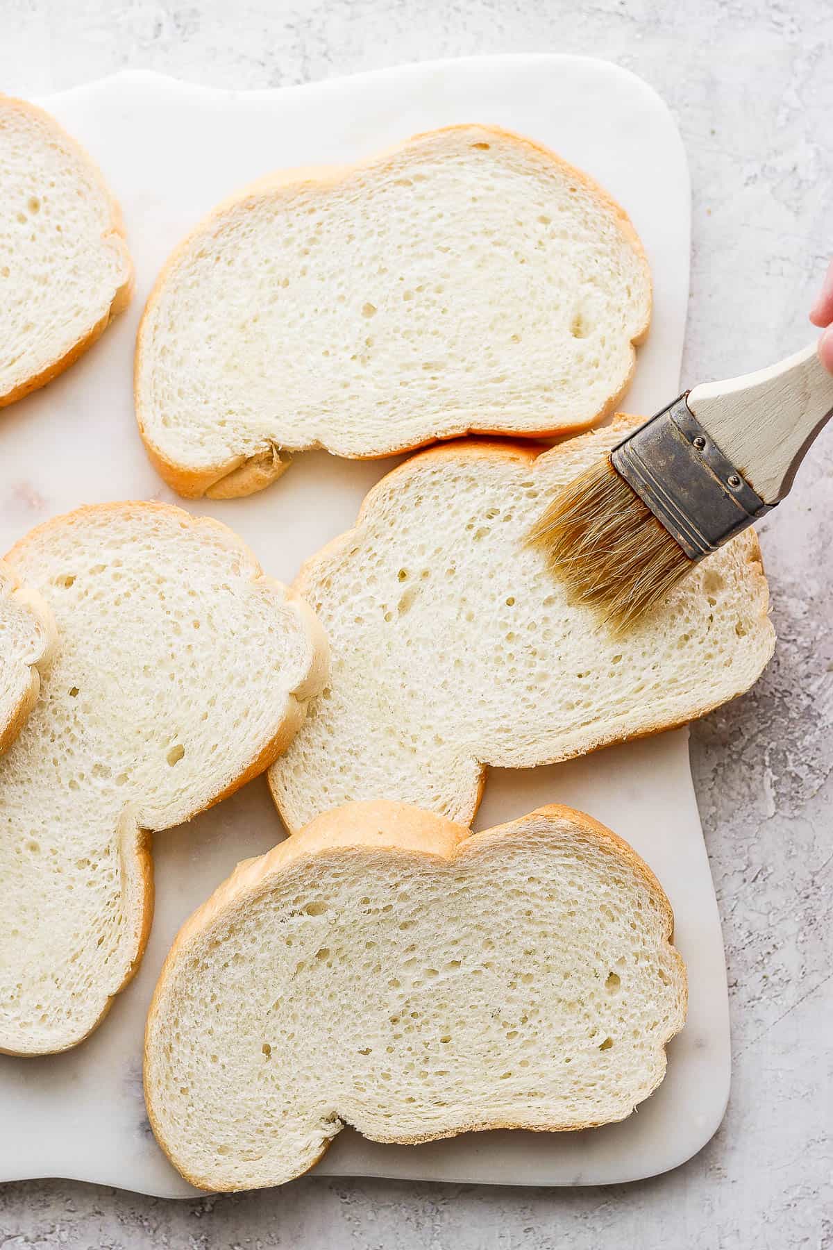 Brushing olive oil on a slice of bread.