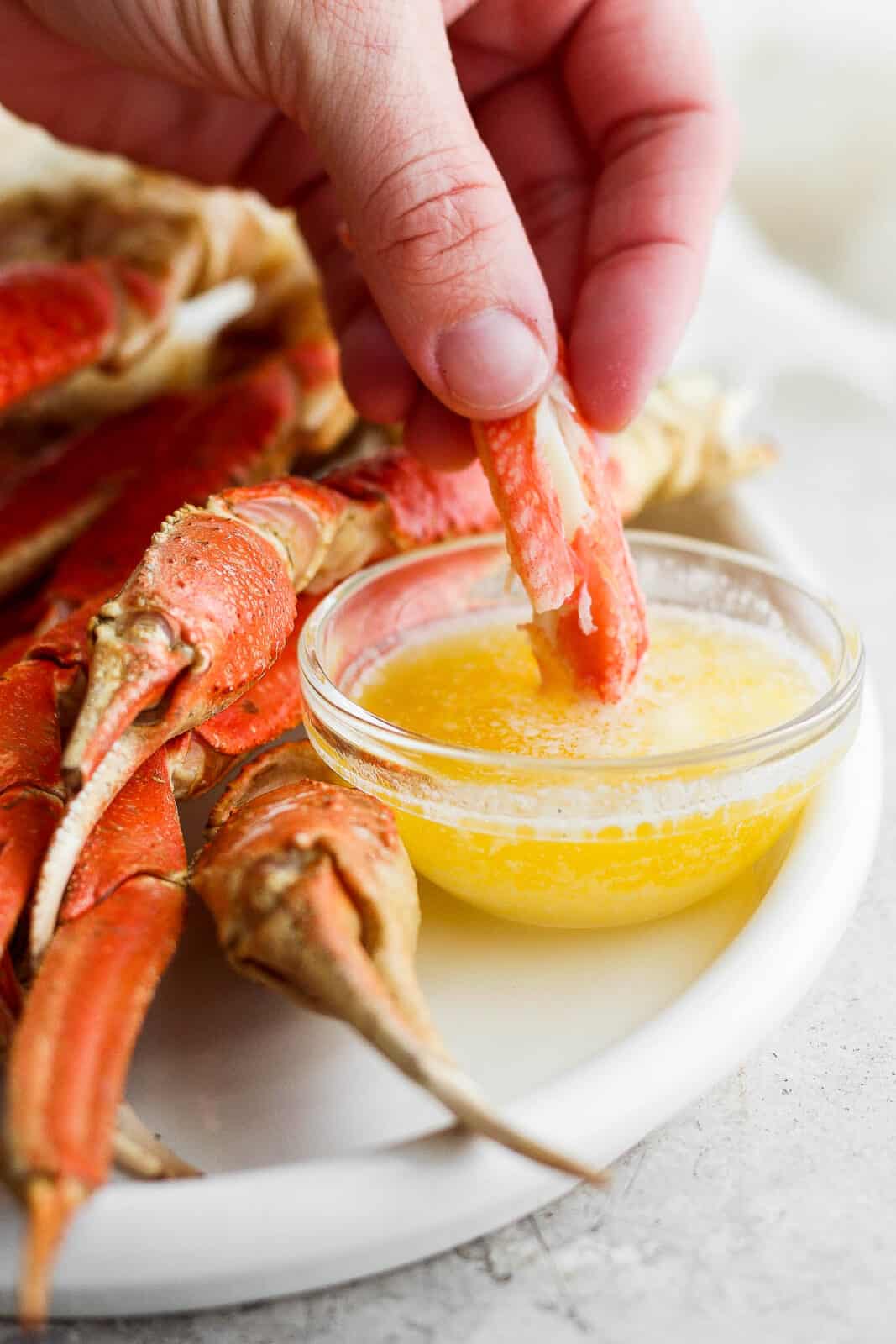 Crab meat being dipped in melted butter.