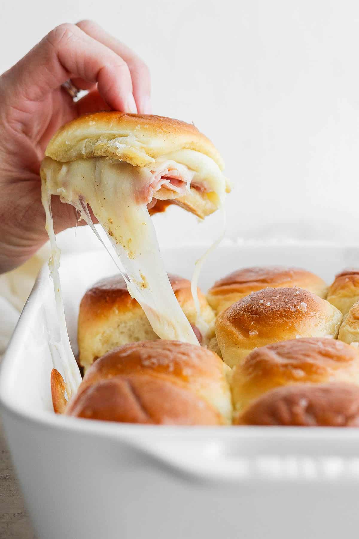 A ham and cheese slider being pulled out.