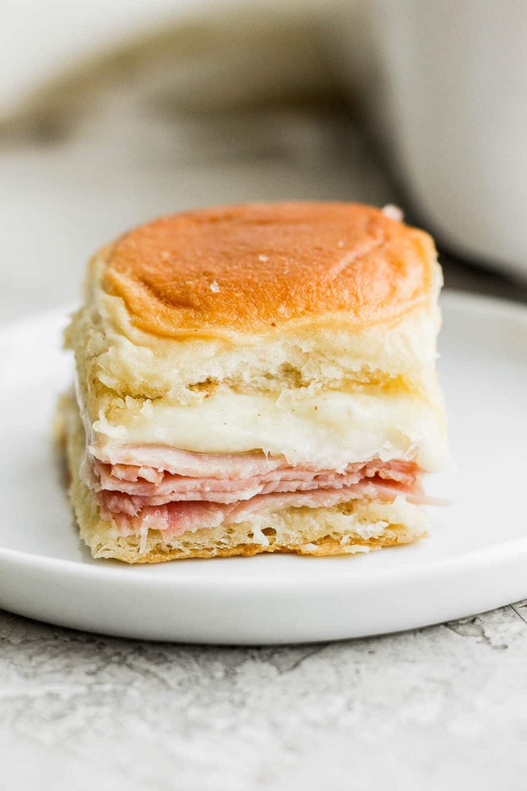 A ham and cheese slider on a plate.