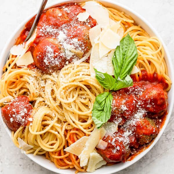Bowl of spaghetti with pesto meatballs and sauce.