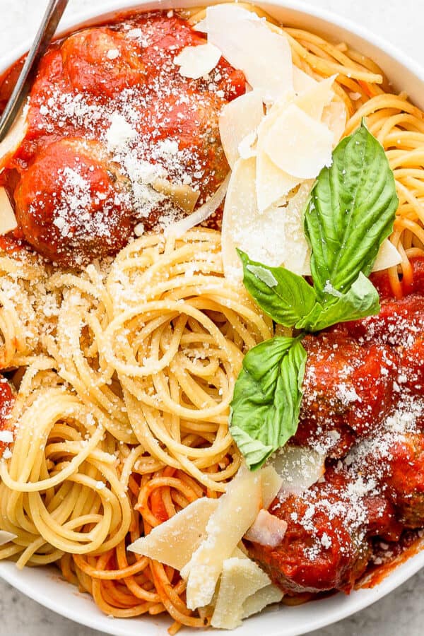 Bowl of spaghetti with pesto meatballs and sauce.