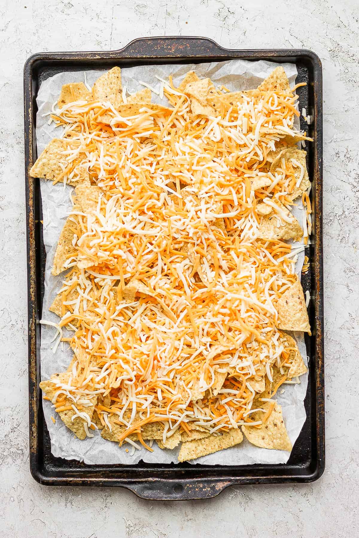 Shredded cheese added to the tortilla chips.