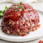 Smoked meatloaf on a plate with glaze on top.