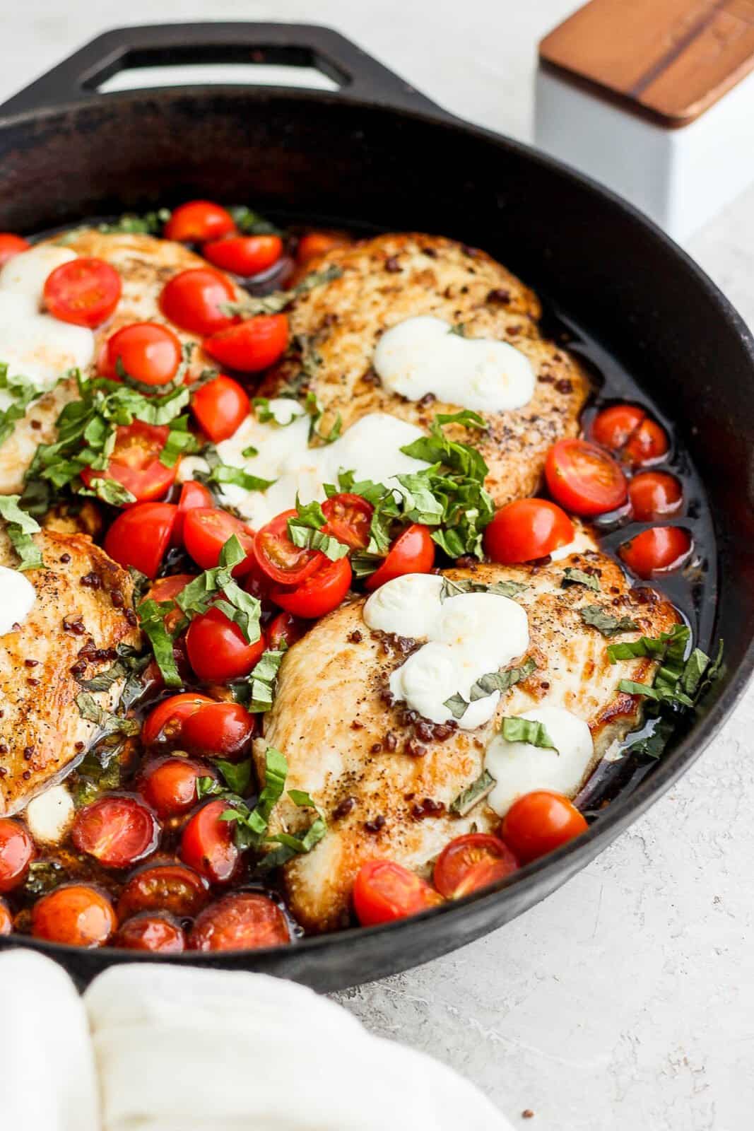 Side angle of the cast iron skillet of balsamic chicken. 