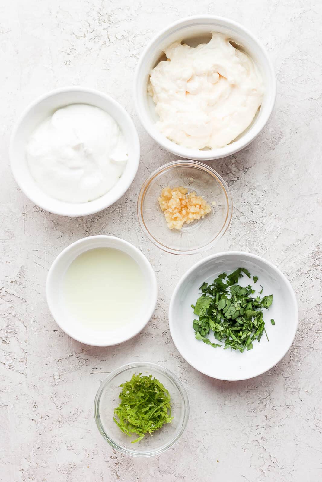 Ingredients for cilantro lime crema in separate bowls.