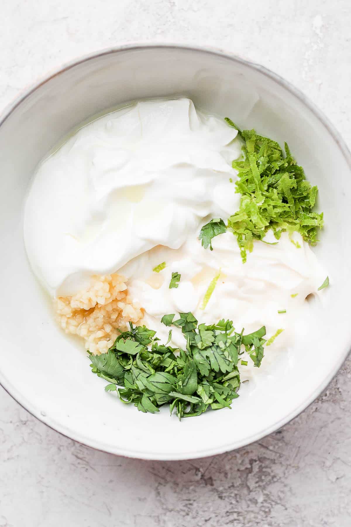 Ingredients for cilantro lime crema in a bowl.