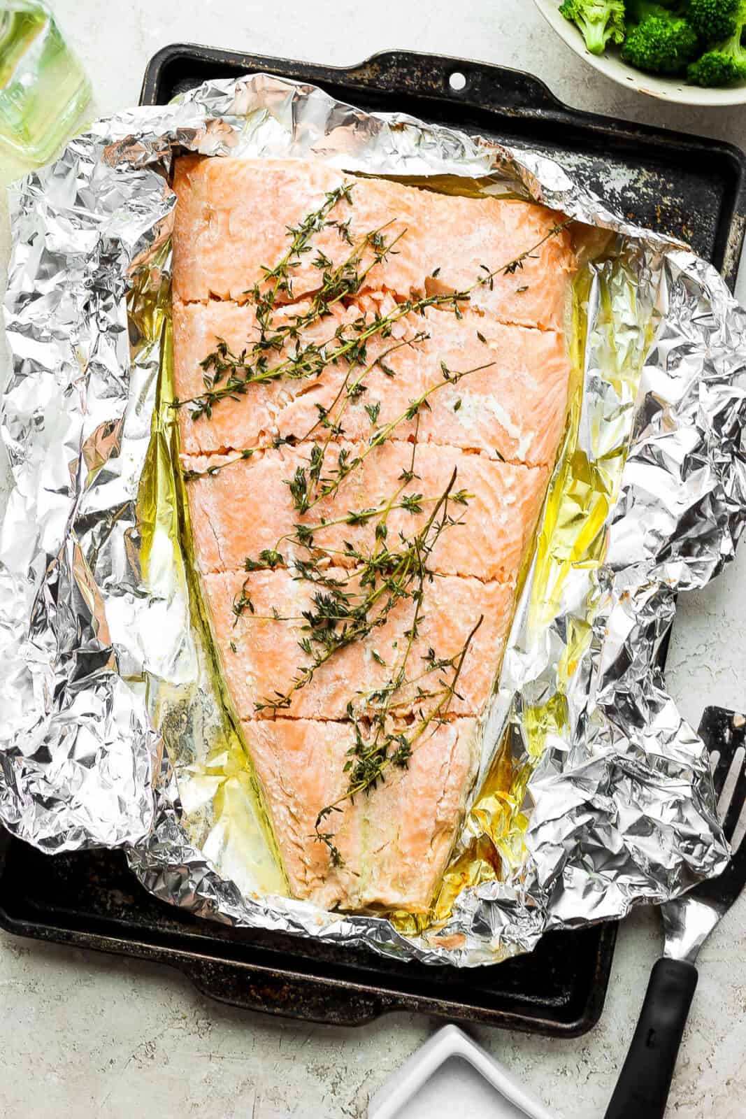 Simple baked salmon in foil on a baking sheet after being removed from the oven.