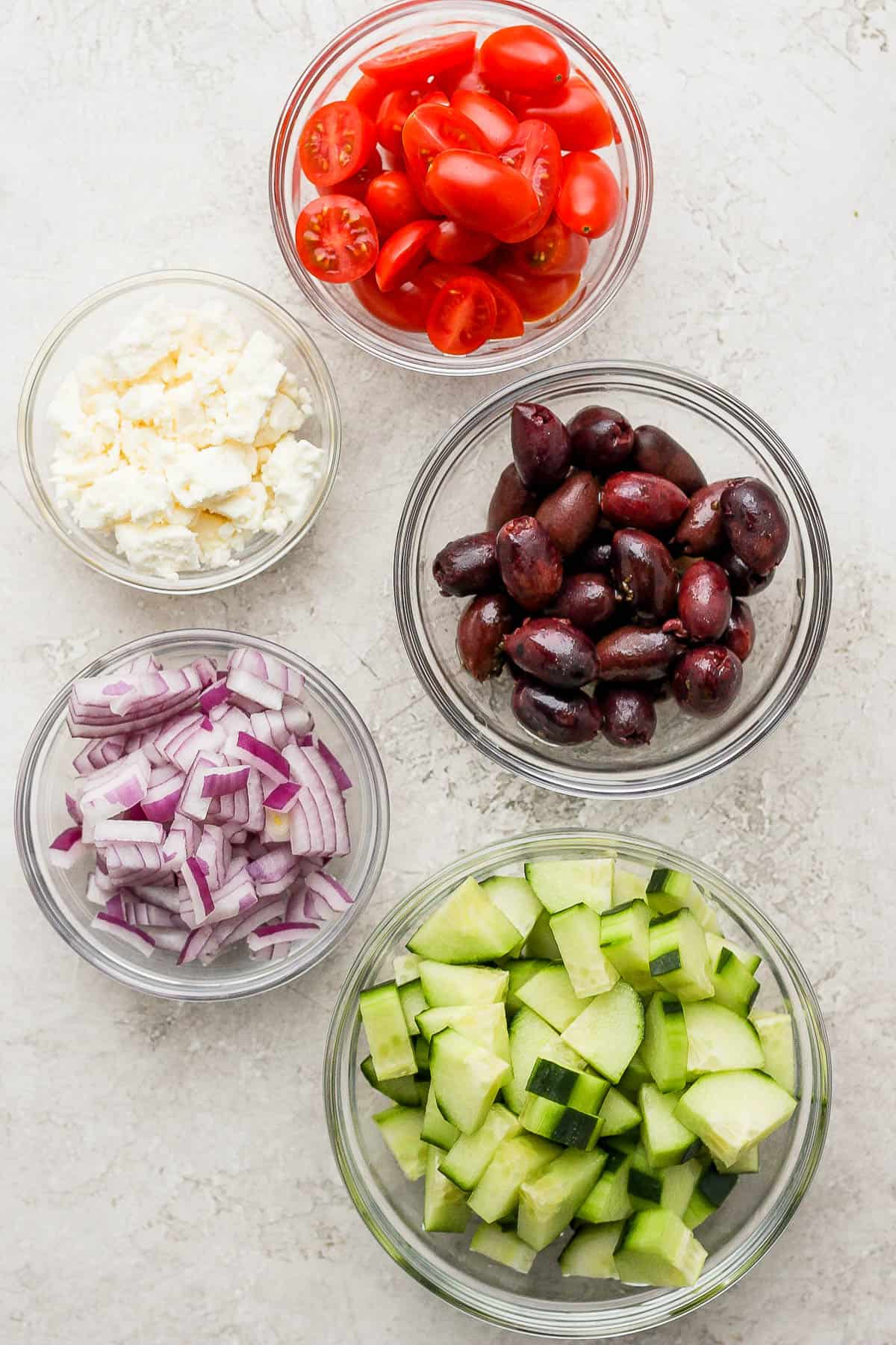 Ingredients for greek orzo salad in little bowls. 