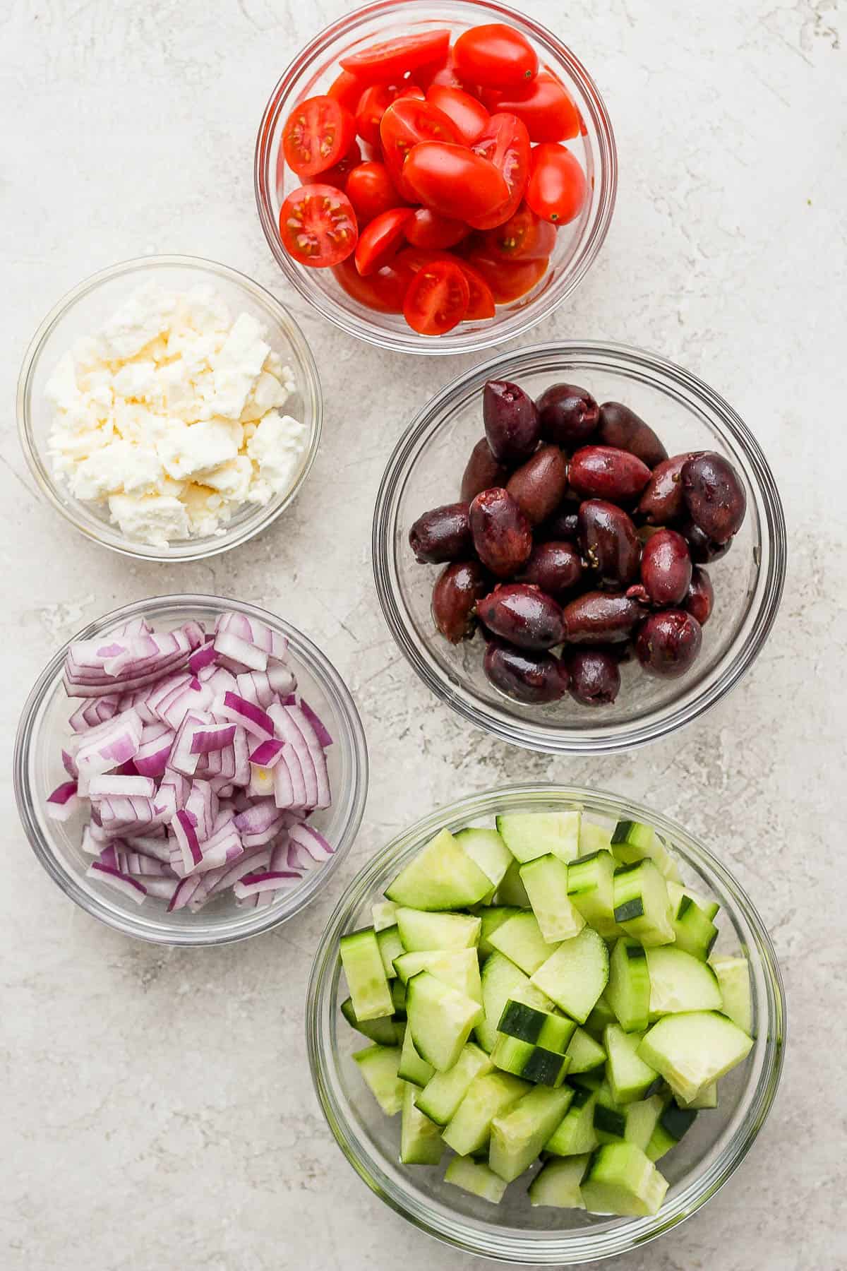 Fresh ingredients for the greek orzo pasta in small bowls.