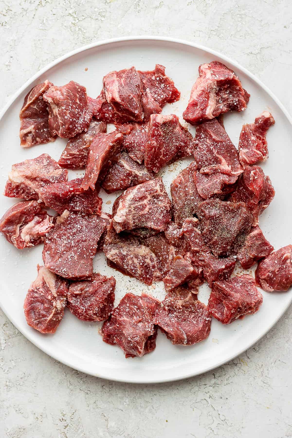 Plate of steak bites seasoned with salt and pepper. 