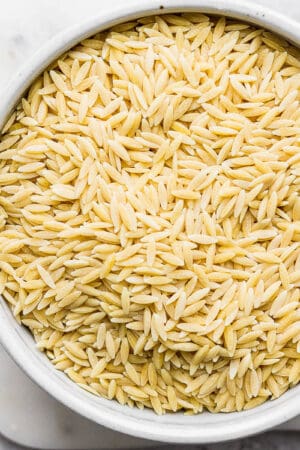 A bowl of uncooked orzo.