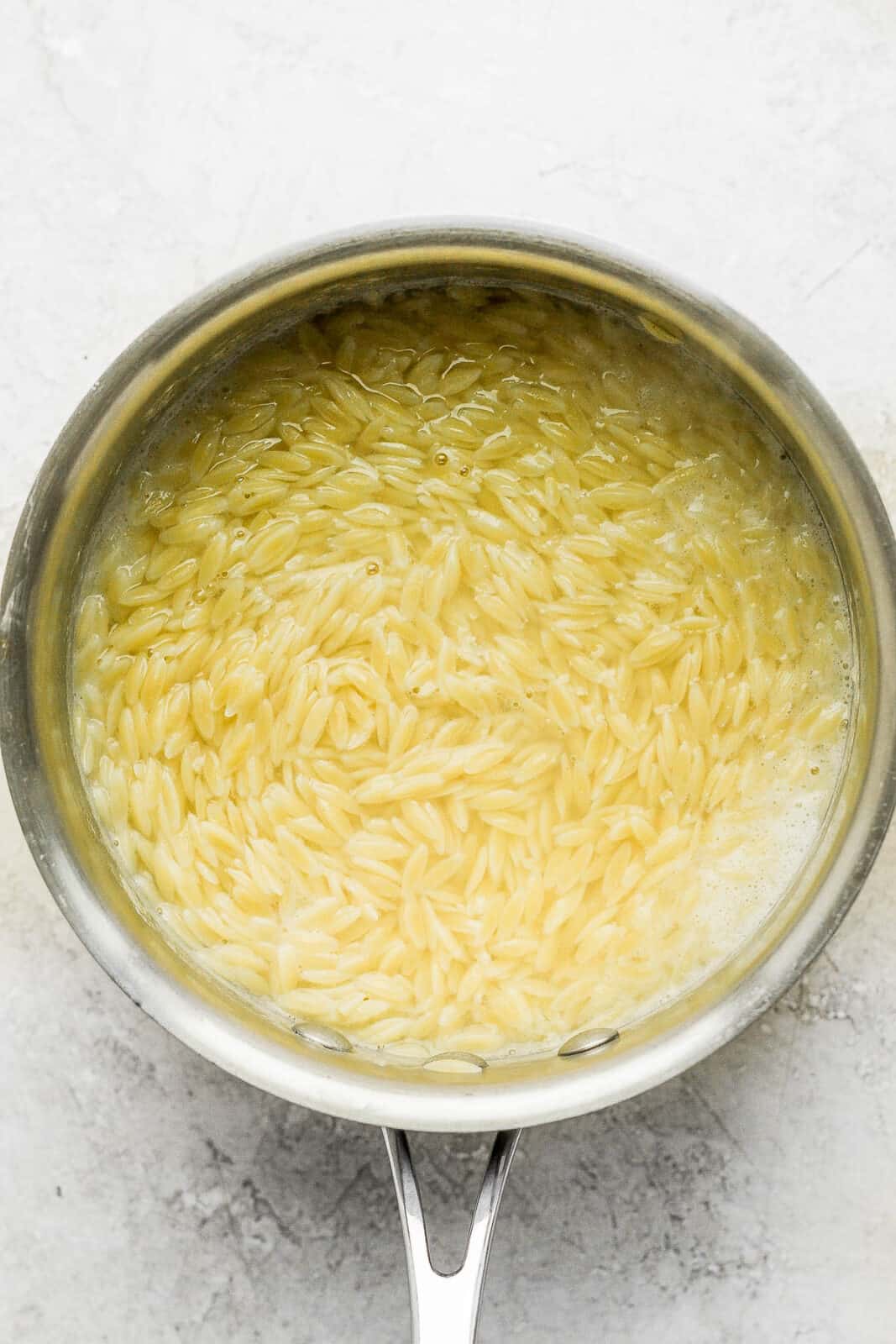 Cooked orzo still in a pot of water.