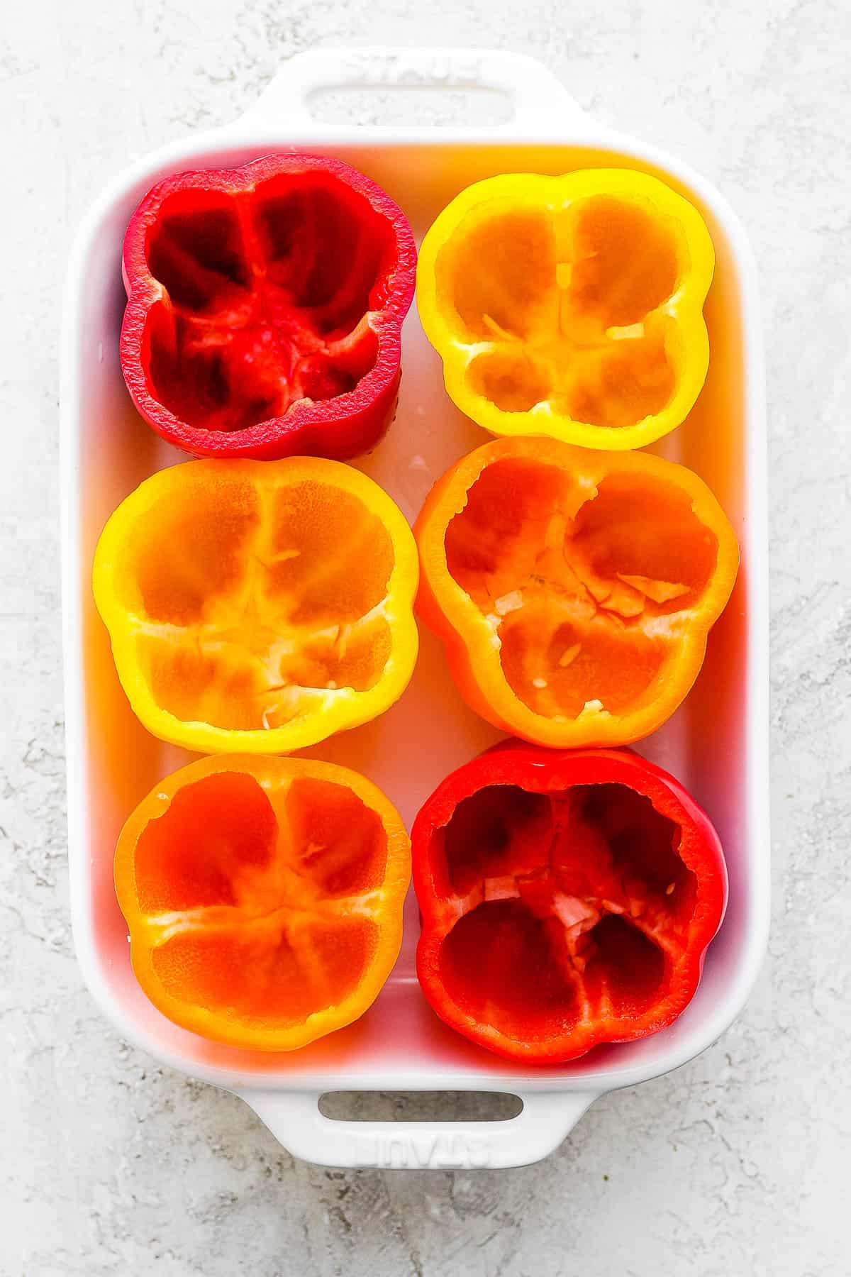 Six bell peppers prepped for baking.