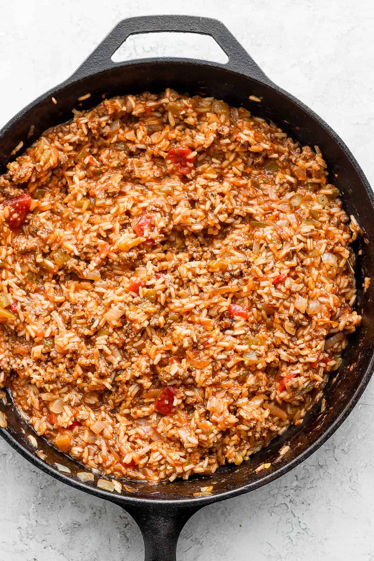 Cast iron skillet with mexican rice inside.