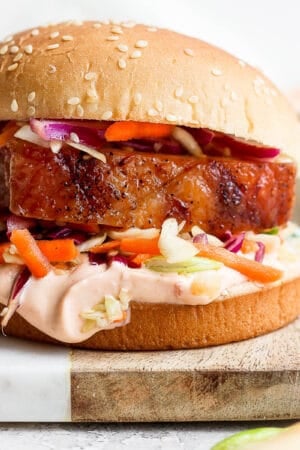 Pork belly sandwich on a wooden board.