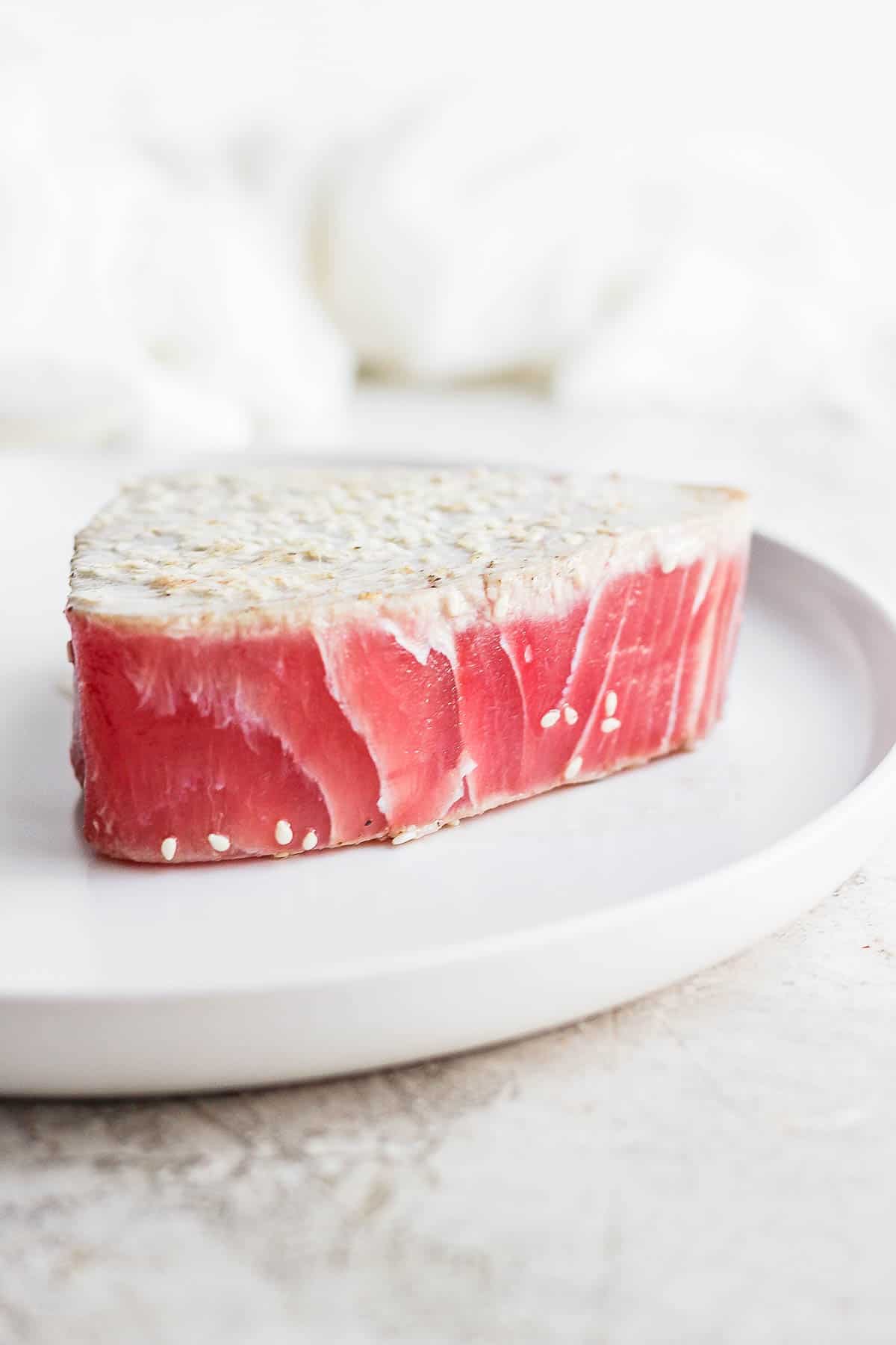 A piece of seared ahi tuna on a plate. 