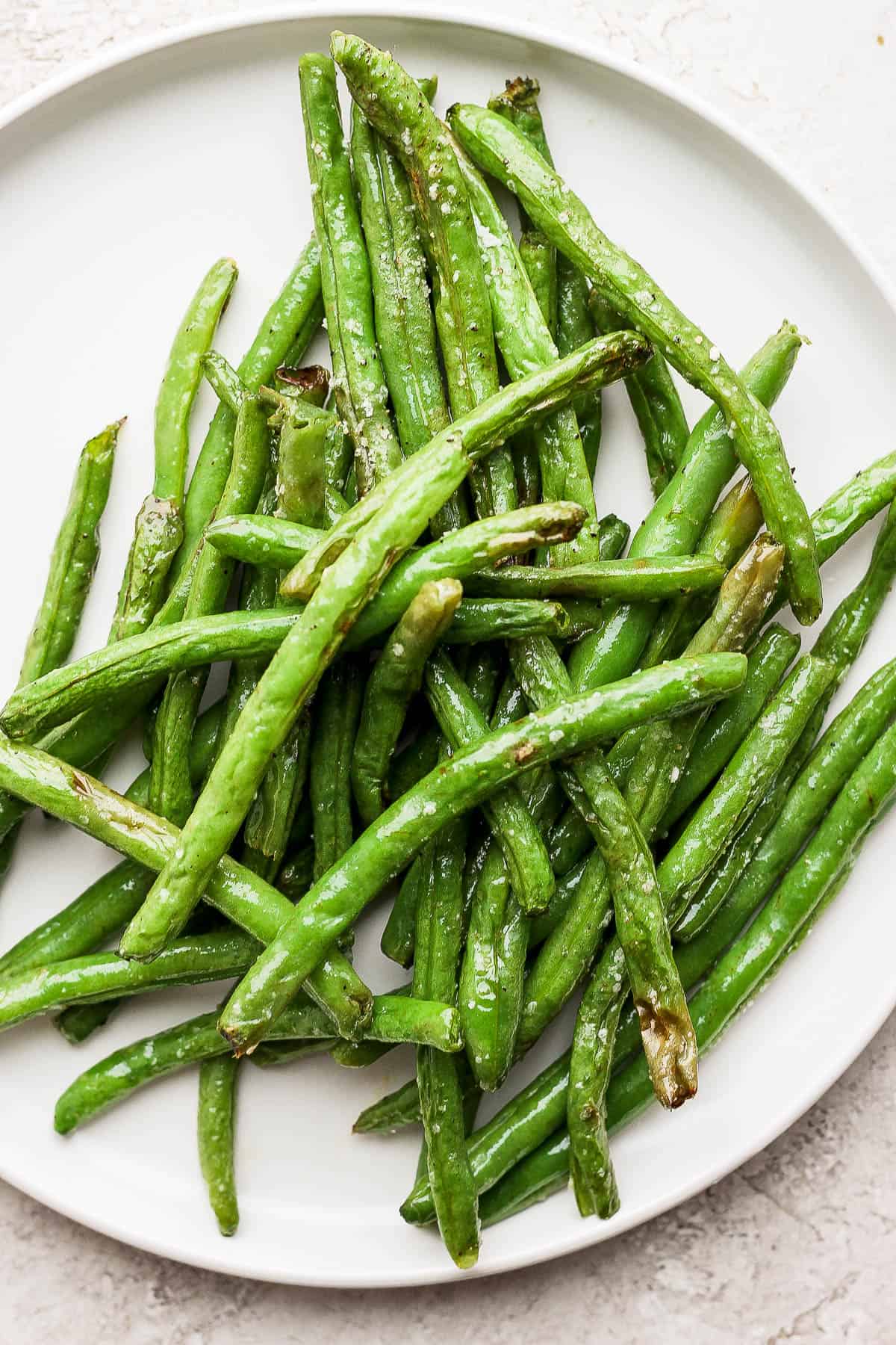 Air fried green beans on a white plate.