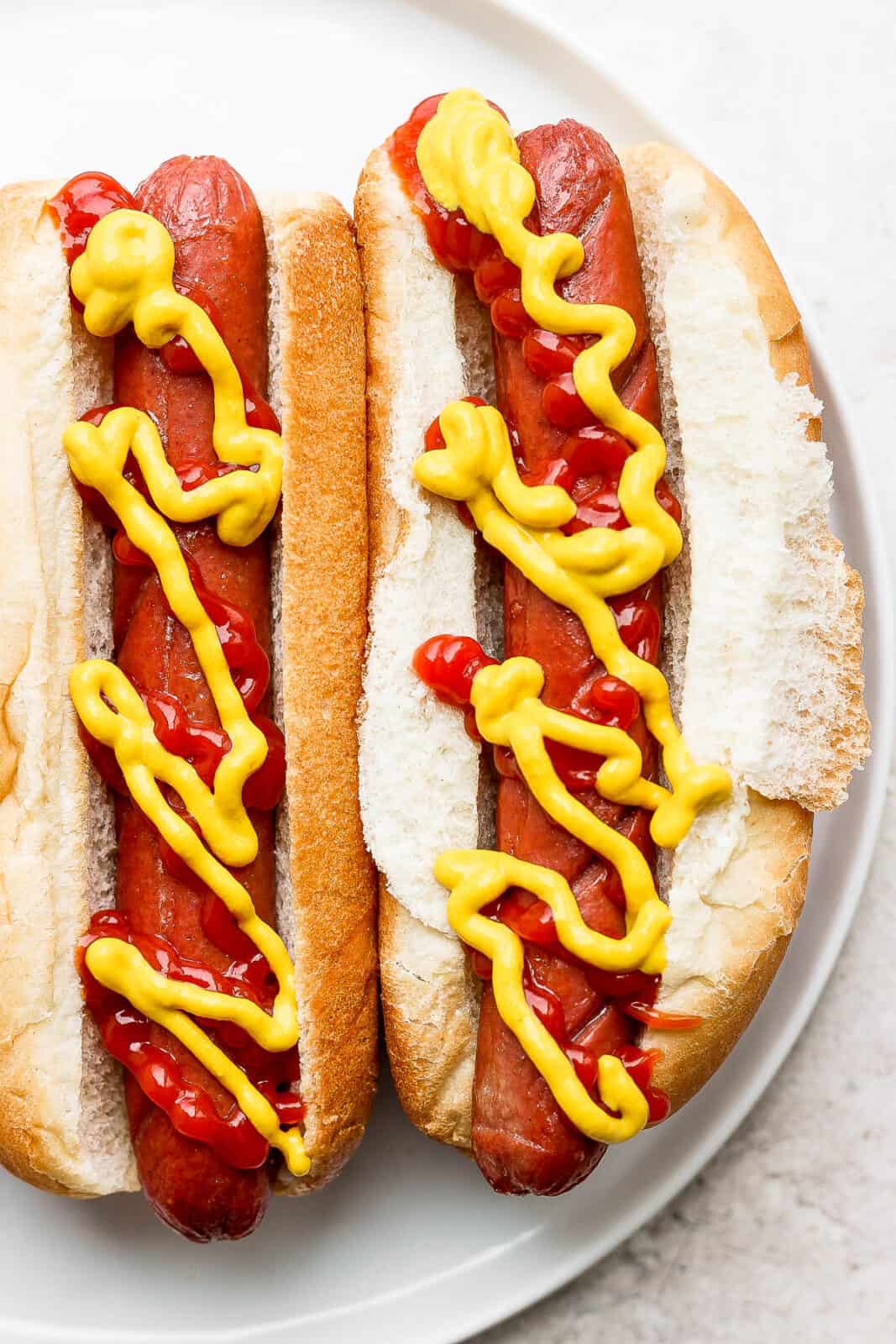 Easy air fried hot dogs on buns with ketchup and mustard.