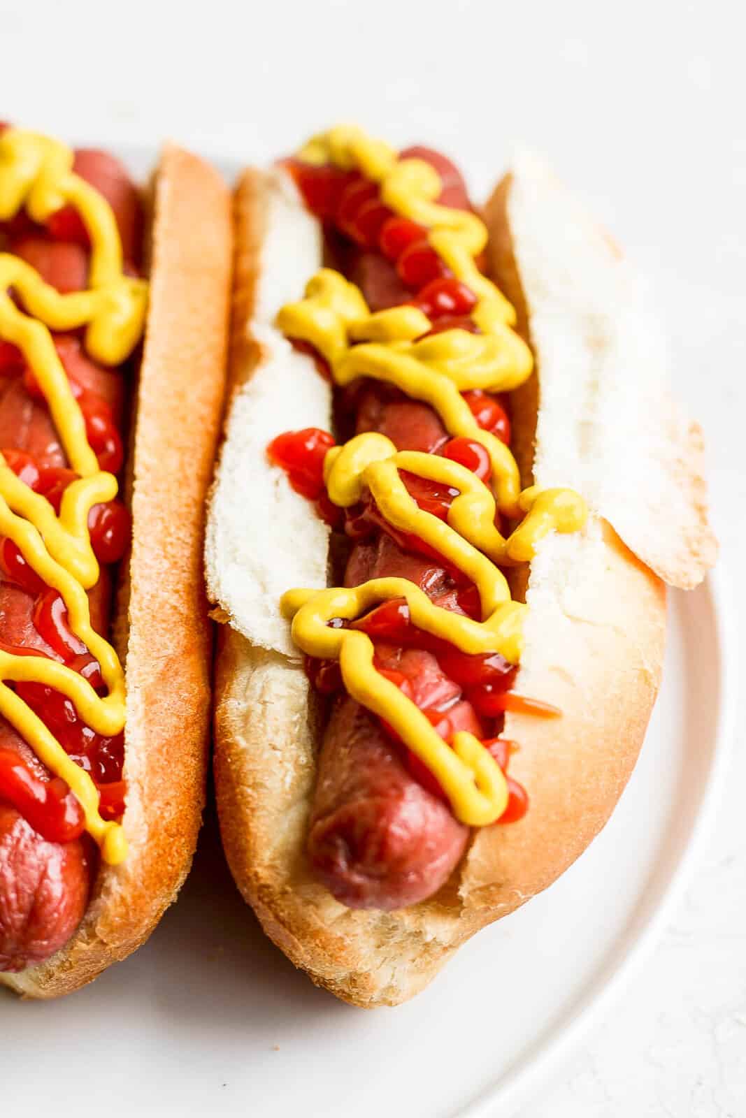 Air fried hot dogs in buns with ketchup and mustard.