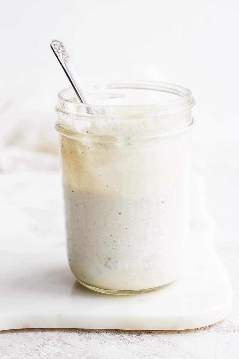 Blue cheese dressing in a mason jar with a spoon.