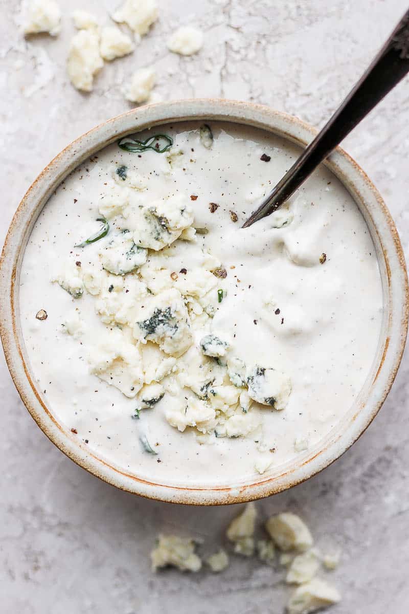 Homemade blue cheese dressing in a bowl with a spoon.