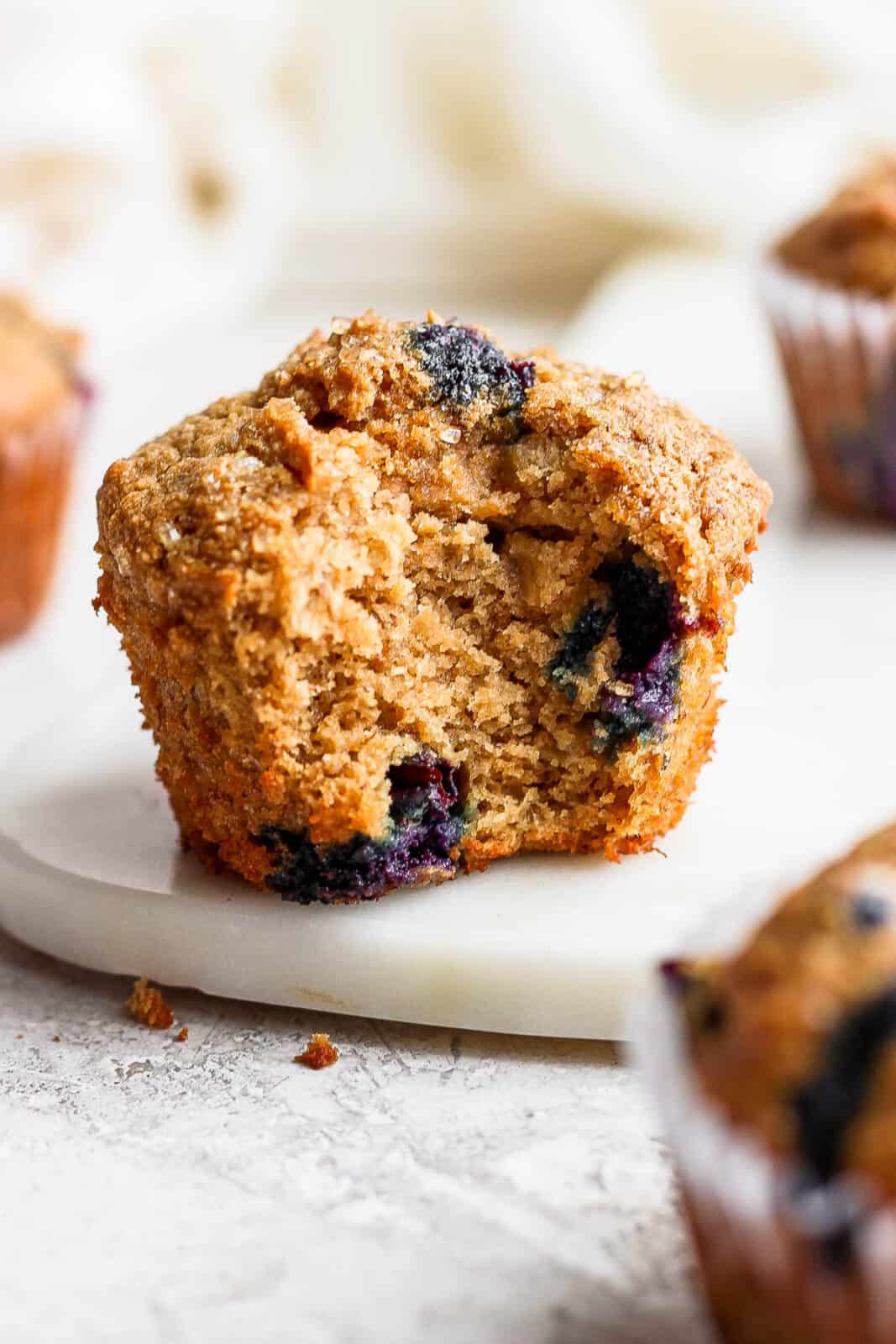 A blueberry banana muffin with a bite taken out.