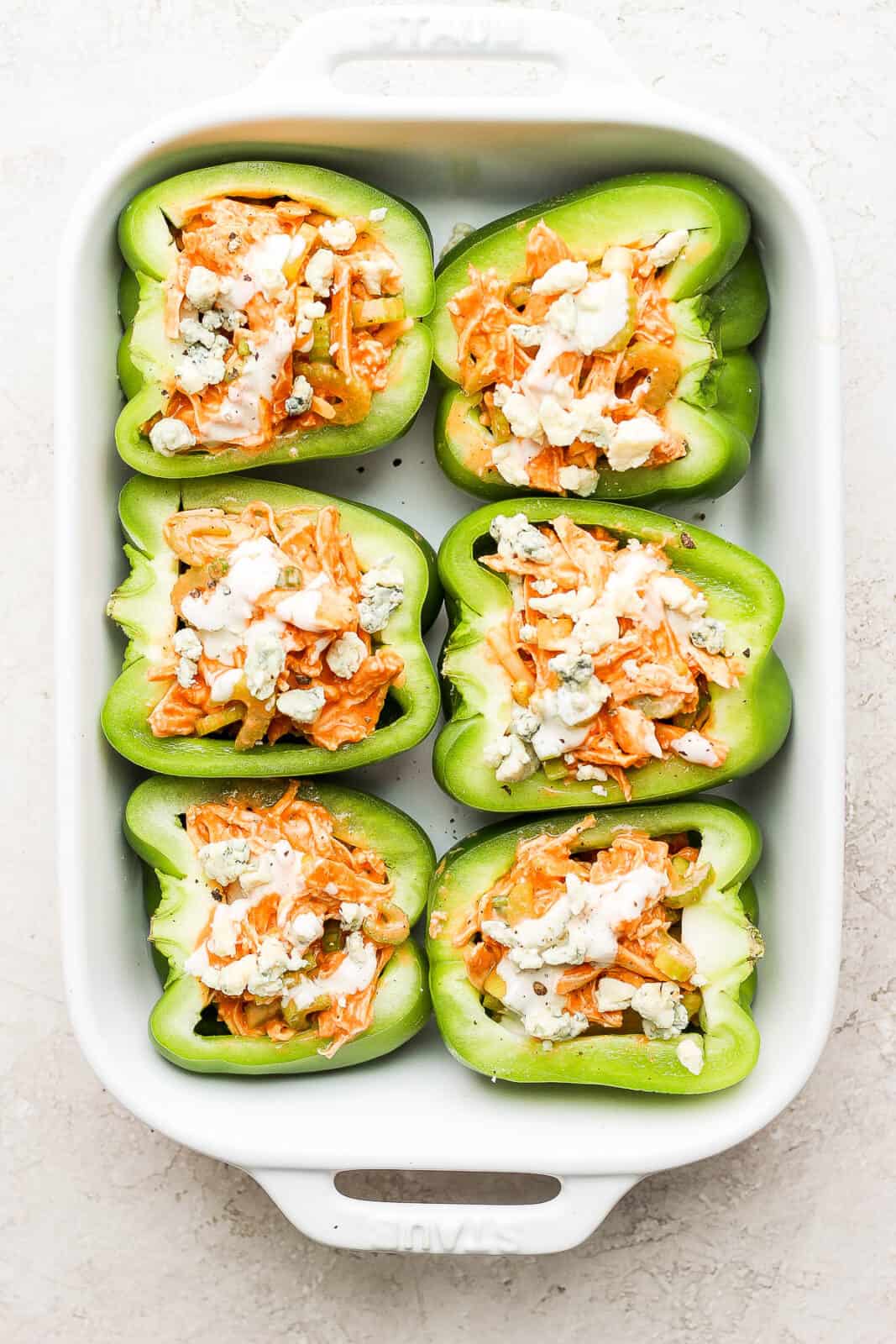 The stuffed peppers in a baking dish.