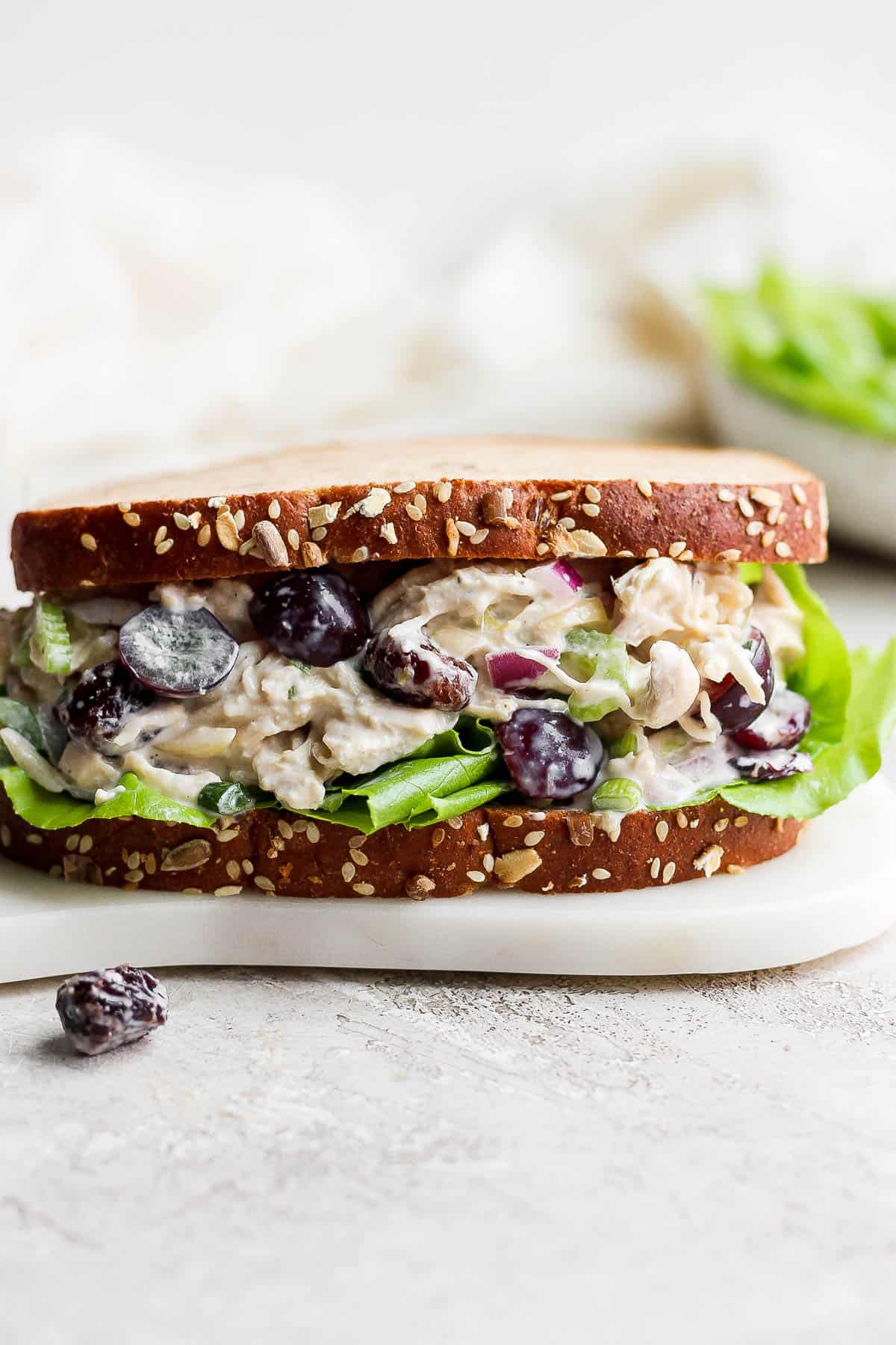 Greek Yogurt Chicken Salad Sandwich on a white cutting board.