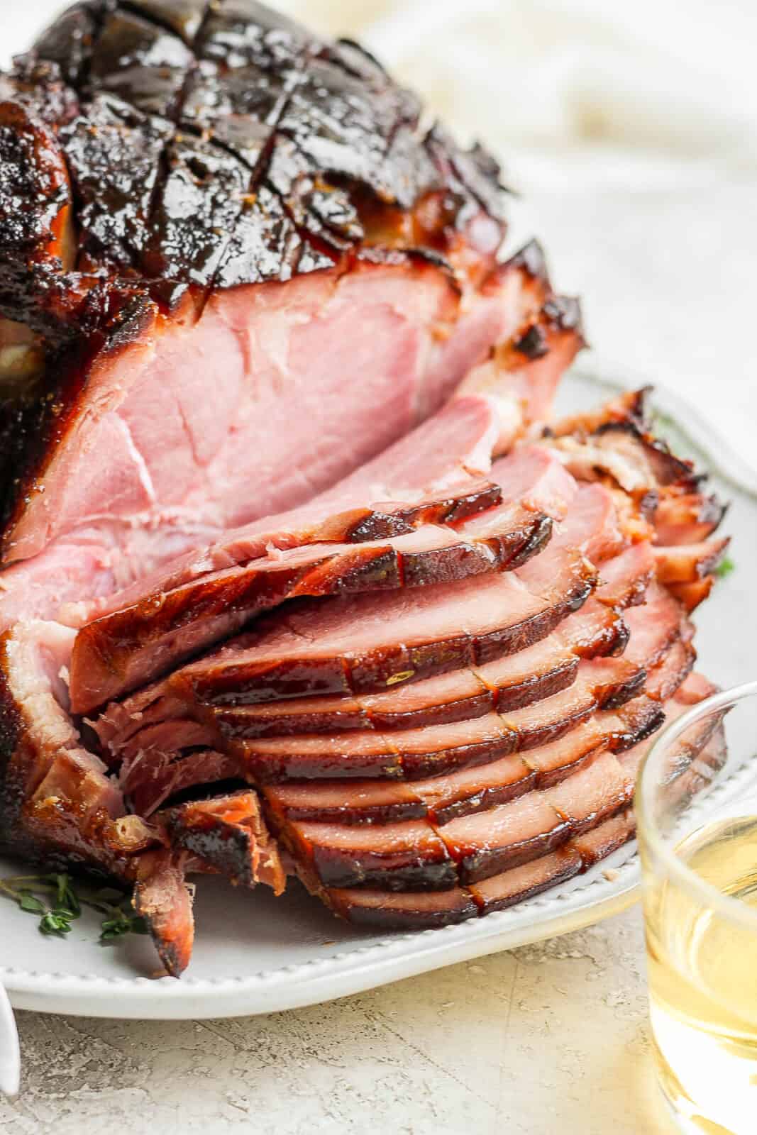 Side shot of a sliced honey glazed ham. 