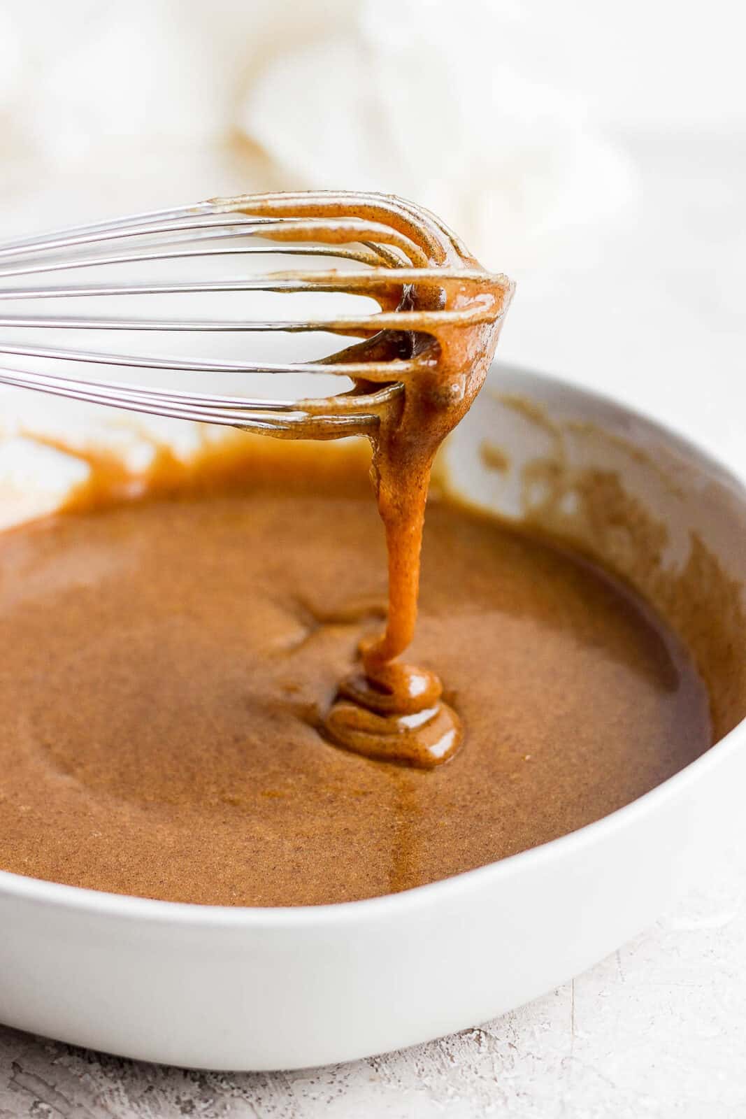 The glaze dripping off the whisk.