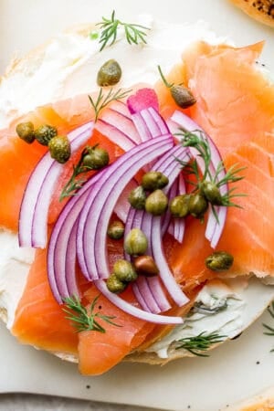Homemade lox on a bagel with red onion and dill.