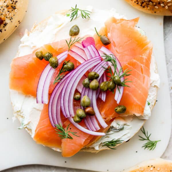 Homemade lox on a bagel with red onion and dill.