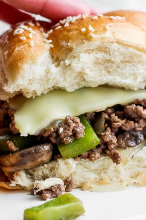 A philly cheesesteak sloppy joe on a plate with chips.