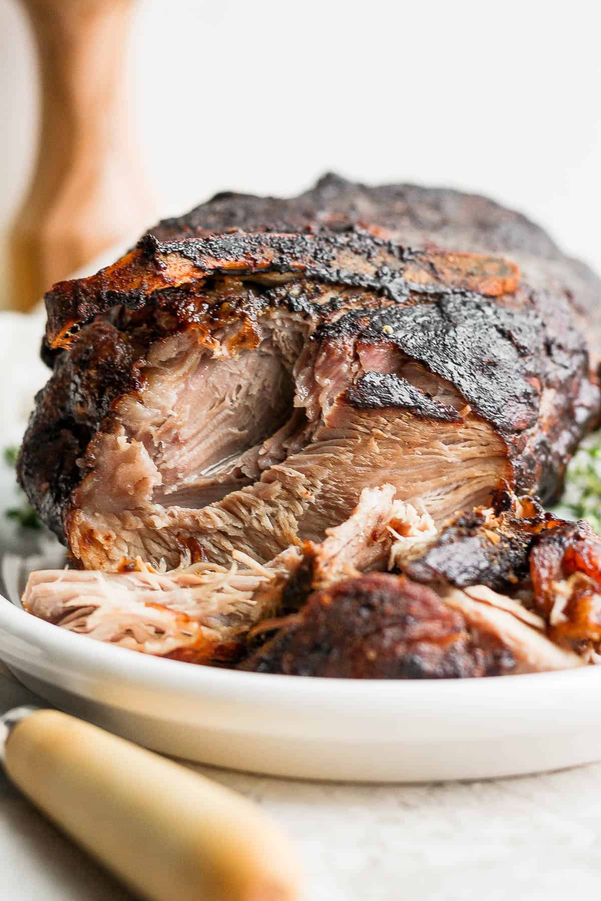 An oven roasted pork shoulder on a platter.