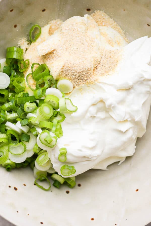 Bowl of scallion cream cheese ingredients in a bowl, but not mixed up yet.