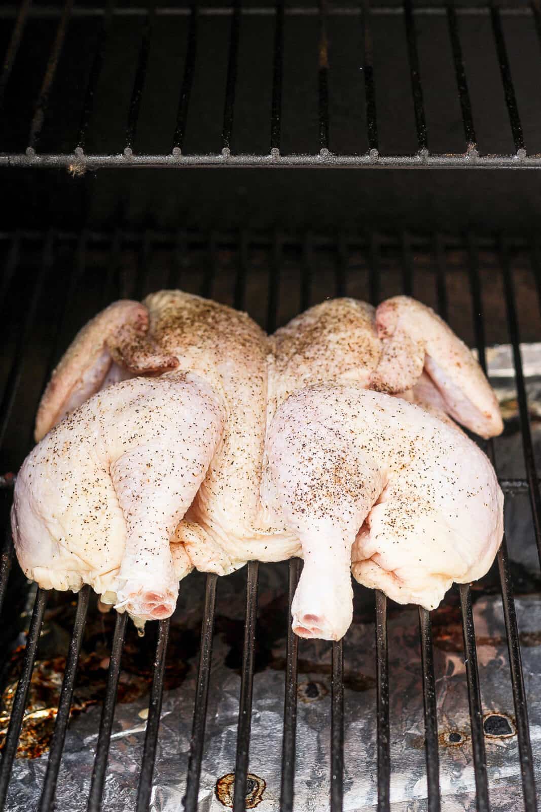 A spatchcock chicken on the smoker, still raw.