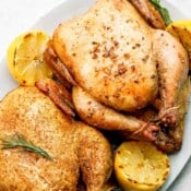 Two smoked whole chickens on a platter.