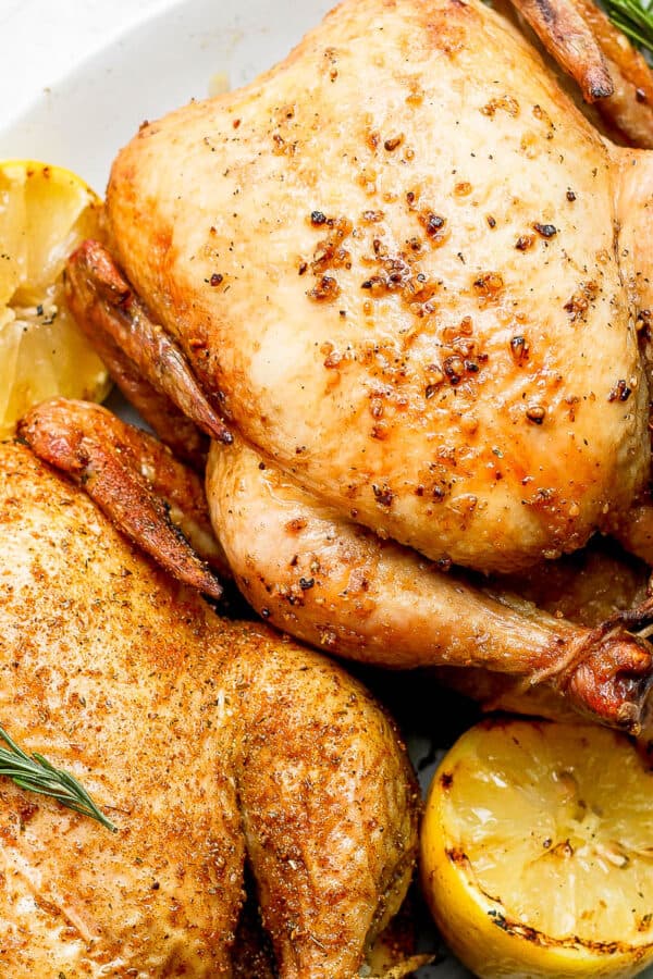 Two smoked whole chickens on a platter.