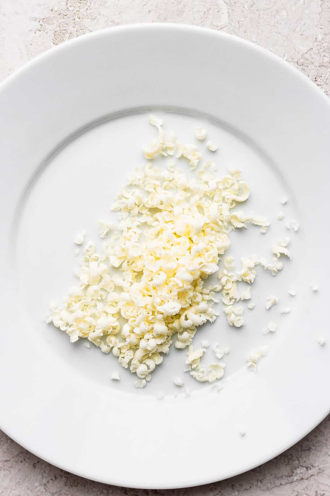 A couple tablespoons of grated frozen butter on a plate.