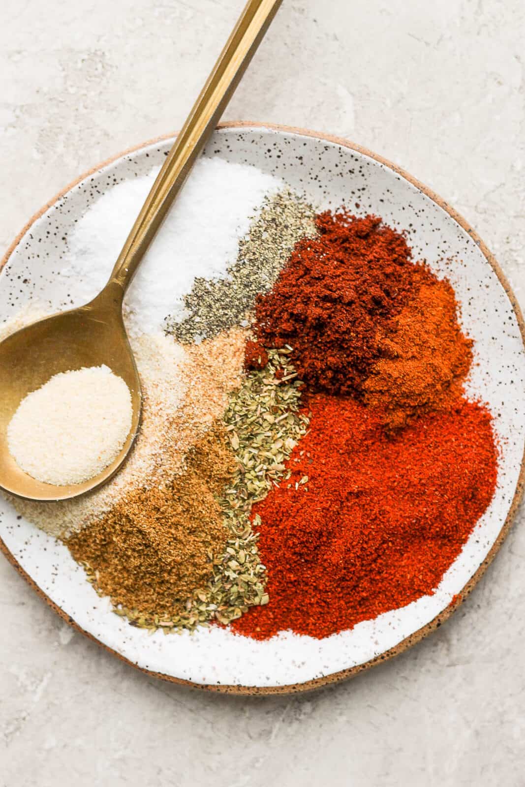 All ingredients for chipotle seasoning on a plate with a spoon.