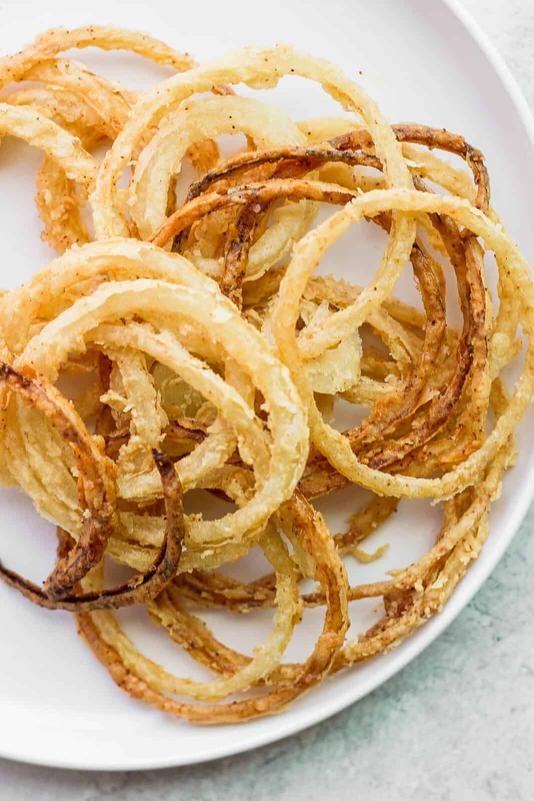 Easy, crispy fried onion strings on a plate.