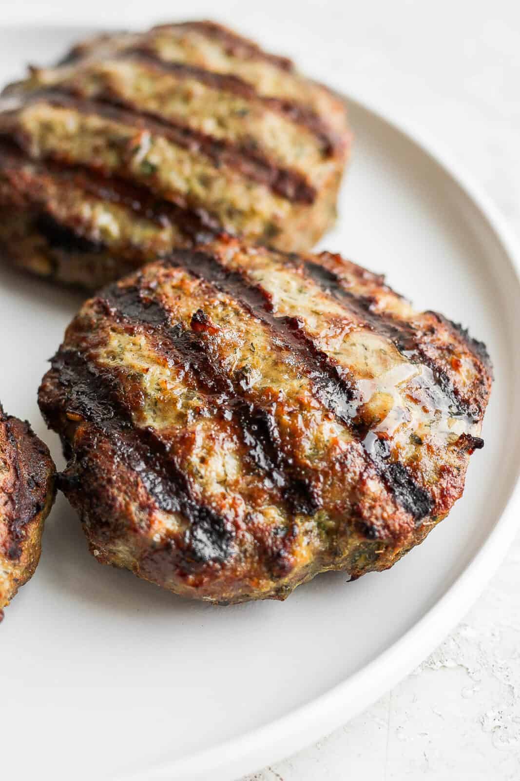 Grilled lamb burger patties on a plate.