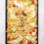 A cookie sheet filled with mexican street corn nachos.