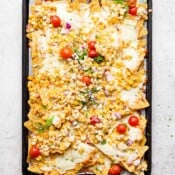 A cookie sheet filled with mexican street corn nachos.