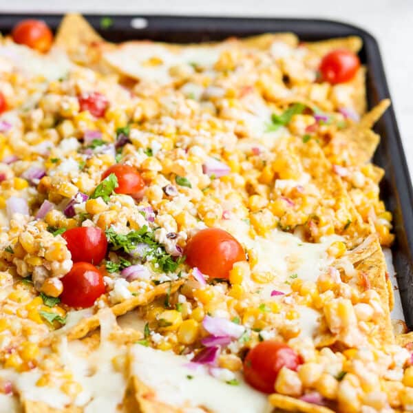 A cookie sheet filled with mexican street corn nachos.
