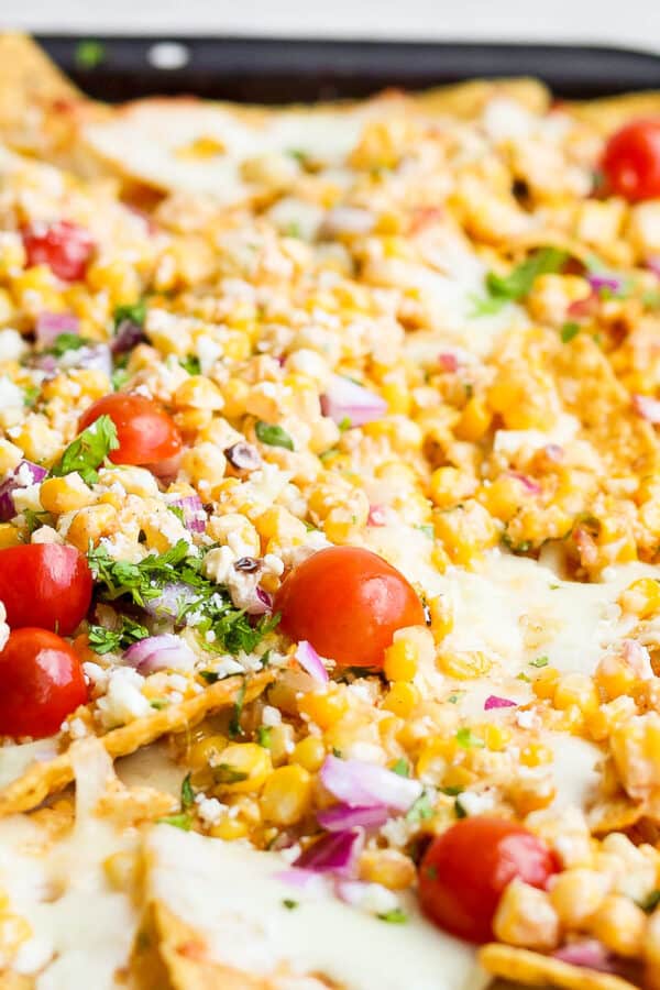 A cookie sheet filled with mexican street corn nachos.