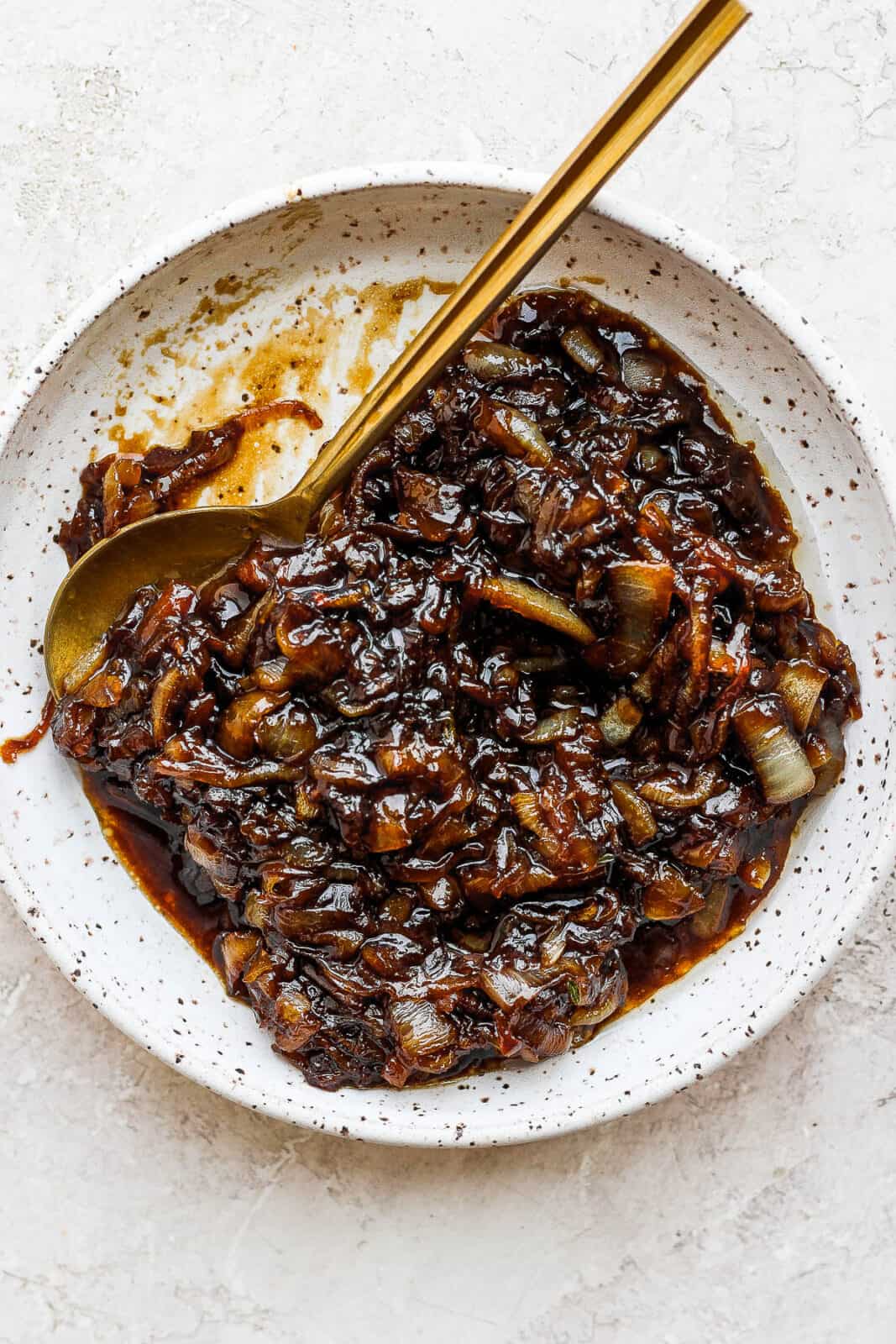 Easy caramelized onion jam on a plate with a spoon.